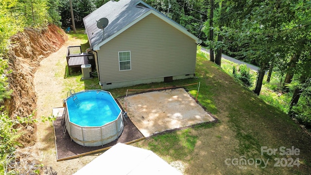 exterior space featuring central AC unit, a lawn, and a deck