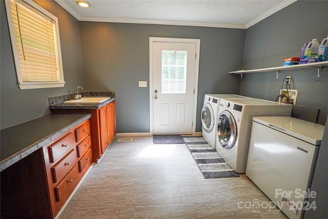 laundry area featuring separate washer and dryer, crown molding, light hardwood / wood-style flooring, and sink