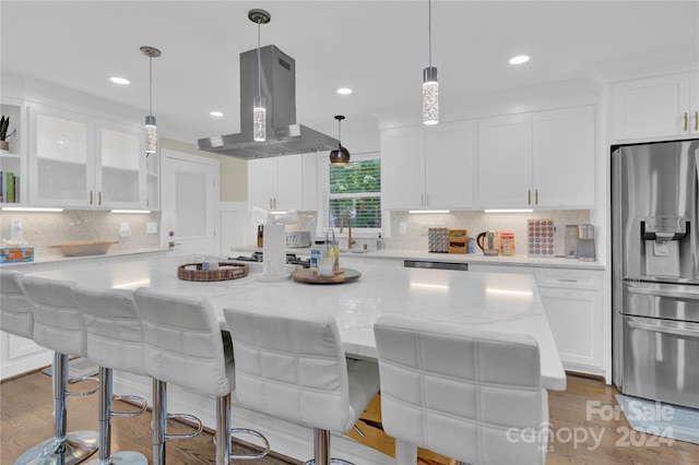 kitchen with white cabinets, appliances with stainless steel finishes, island range hood, and a center island