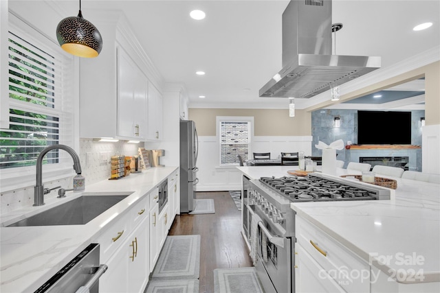 kitchen featuring decorative light fixtures, island exhaust hood, white cabinetry, stainless steel appliances, and light stone counters