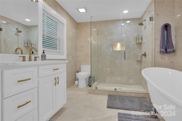 full bathroom with toilet, independent shower and bath, tile walls, and vanity