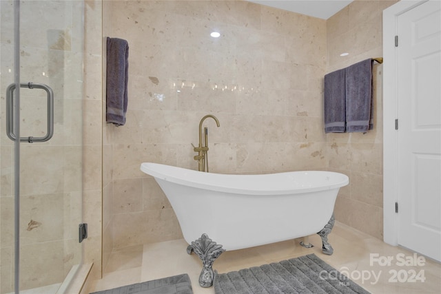 bathroom featuring a bathtub, tile walls, and tile patterned floors