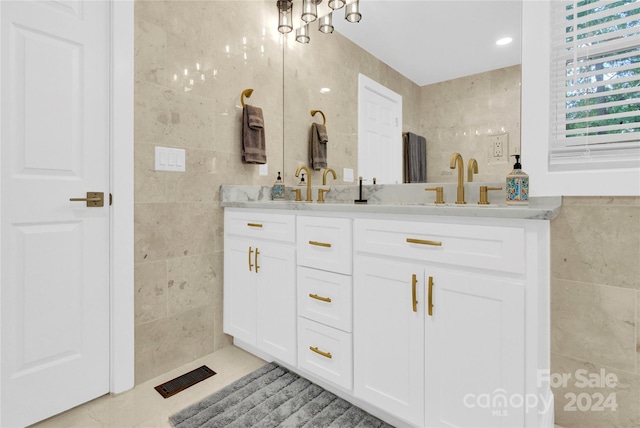 bathroom with tile walls, vanity, and tile patterned flooring