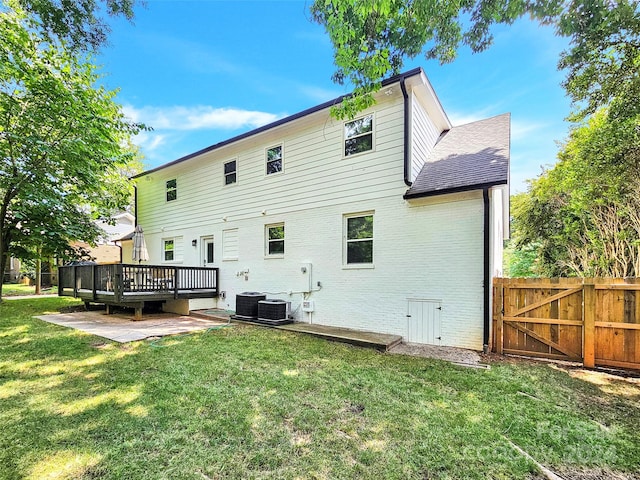 back of property featuring a deck, cooling unit, a yard, and a patio