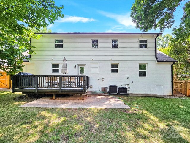 back of property featuring a deck, cooling unit, a yard, and a patio