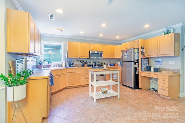 kitchen with tile counters, light brown cabinetry, crown molding, and stainless steel appliances