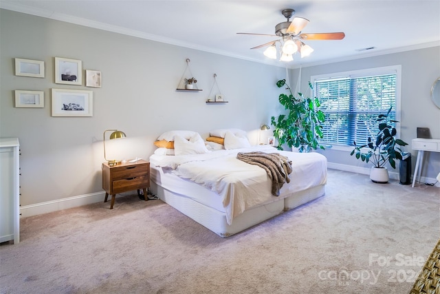 bedroom featuring ceiling fan, ornamental molding, and carpet flooring