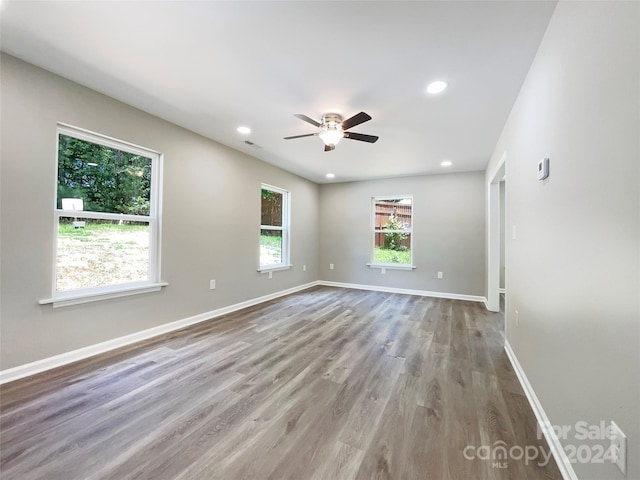 unfurnished room with light wood-type flooring, ceiling fan, and a healthy amount of sunlight