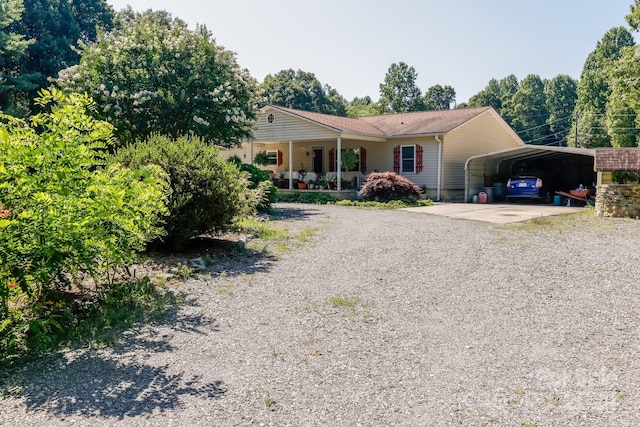 ranch-style house with covered porch and a carport