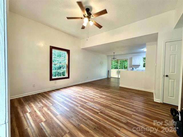 unfurnished living room featuring ceiling fan and dark hardwood / wood-style flooring