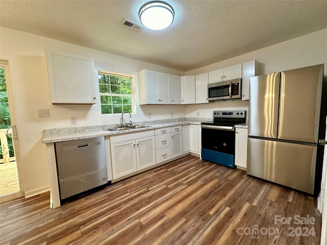 kitchen with sink, white cabinets, a textured ceiling, and appliances with stainless steel finishes