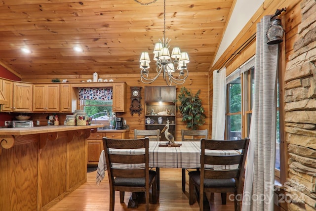 dining area with light hardwood / wood-style floors, wooden ceiling, a chandelier, and vaulted ceiling