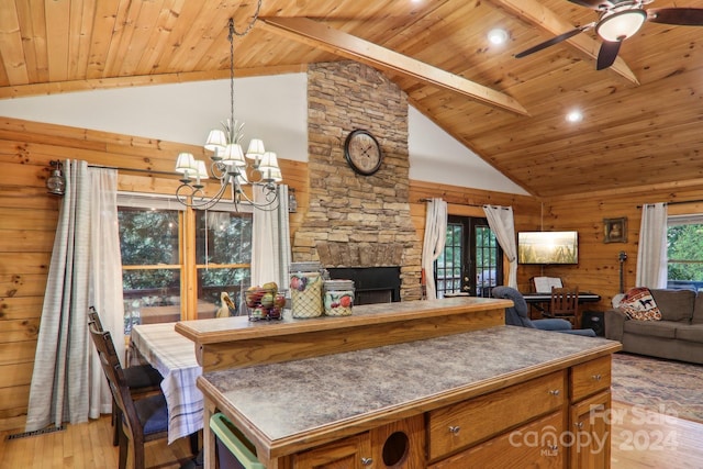 kitchen featuring wood ceiling, light hardwood / wood-style floors, wooden walls, and beamed ceiling