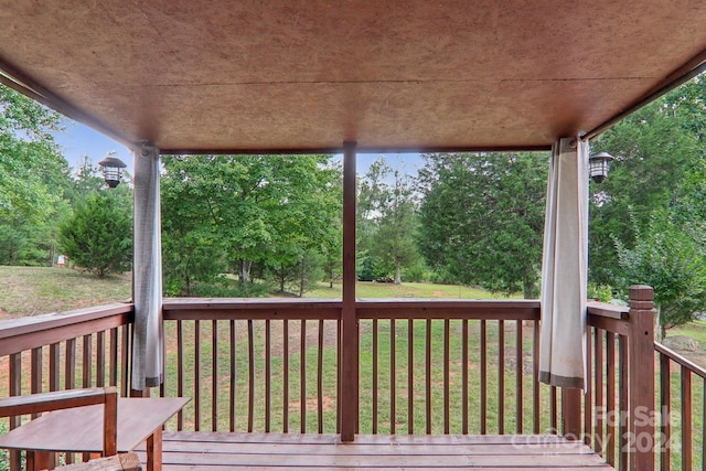 wooden deck featuring a lawn