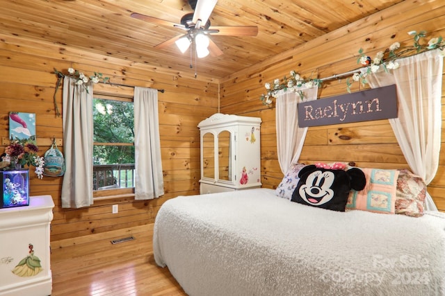 bedroom with ceiling fan, wood-type flooring, wooden walls, and wooden ceiling