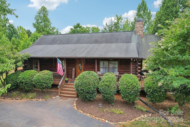 log home featuring a porch