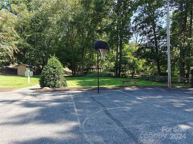 view of basketball court with a yard