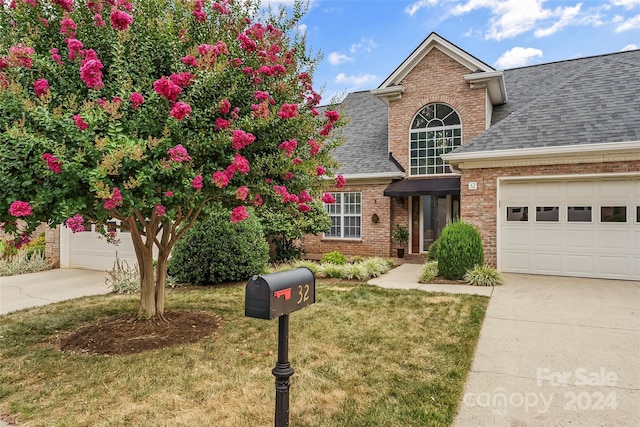 view of property with a garage and a front yard