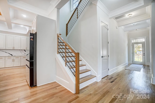 foyer with crown molding, beamed ceiling, light hardwood / wood-style floors, and coffered ceiling