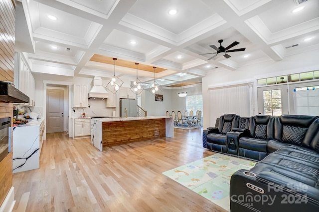 living room with beam ceiling, light hardwood / wood-style flooring, ceiling fan, and coffered ceiling