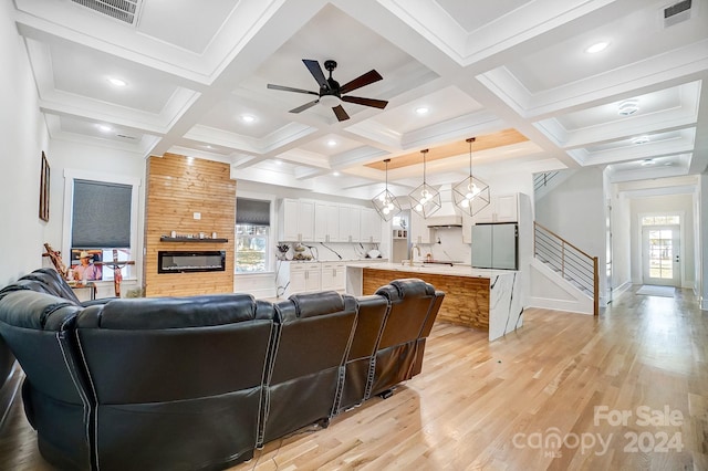 living room featuring coffered ceiling, ceiling fan, sink, beamed ceiling, and light hardwood / wood-style floors