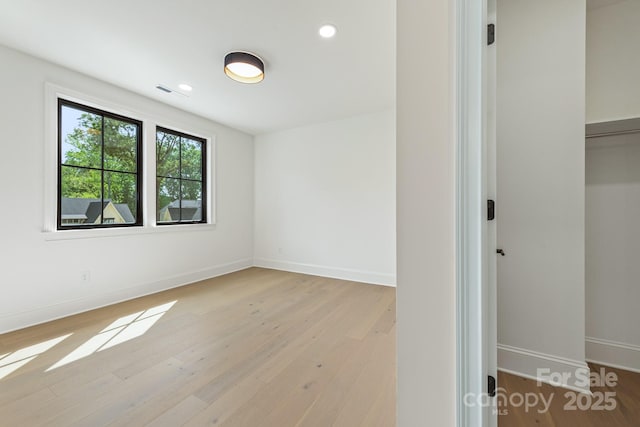 empty room with recessed lighting, baseboards, light wood-type flooring, and visible vents