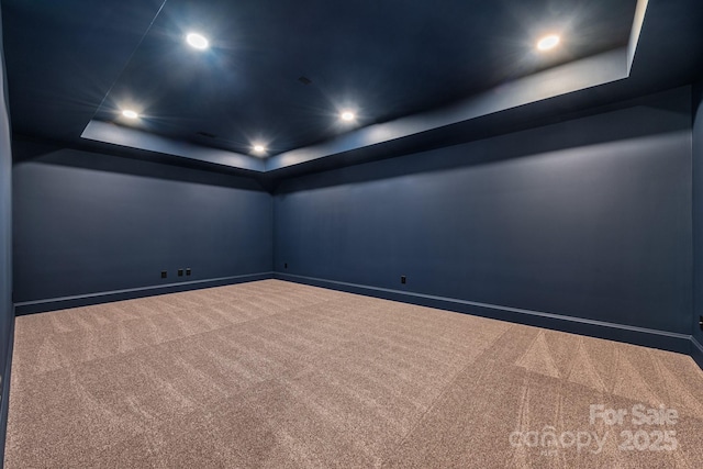 spare room featuring recessed lighting, baseboards, a tray ceiling, and carpet flooring
