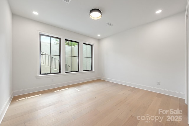 empty room with baseboards, light wood-style flooring, and visible vents