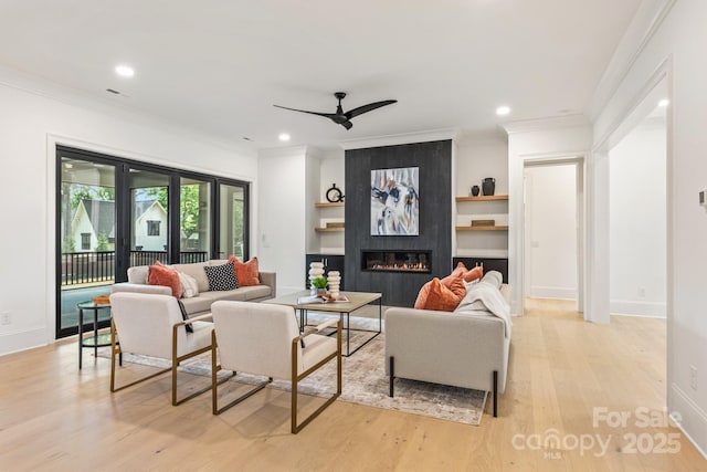 living area with a ceiling fan, recessed lighting, ornamental molding, and light wood finished floors