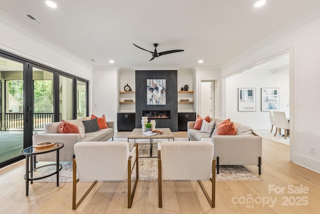 living room featuring ornamental molding, light wood-style flooring, and a ceiling fan