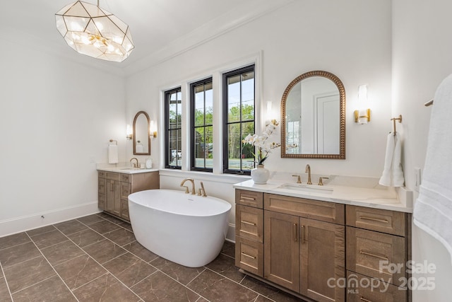 full bathroom featuring a sink, a freestanding tub, marble finish floor, and two vanities