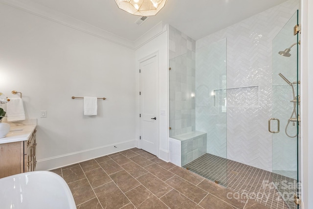 full bathroom featuring vanity, a freestanding tub, baseboards, and a tile shower