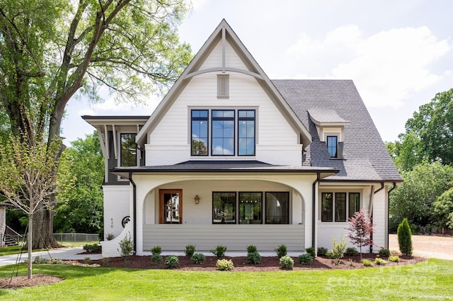 view of front of house featuring brick siding, a front lawn, and roof with shingles