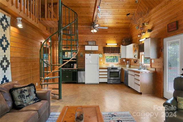 kitchen with wood walls, wood ceiling, appliances with stainless steel finishes, and high vaulted ceiling