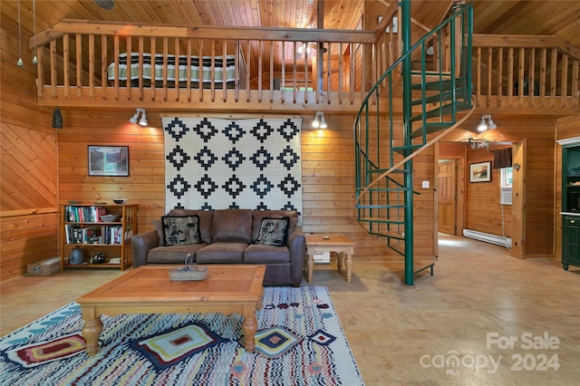 living room featuring wood walls, a baseboard heating unit, concrete flooring, and high vaulted ceiling