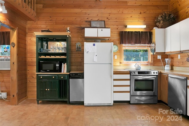 kitchen with wooden walls, stainless steel appliances, and white cabinets