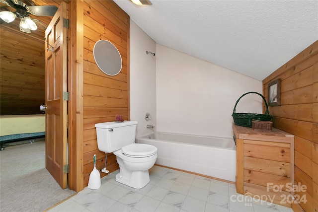 bathroom featuring toilet, vaulted ceiling, wooden walls, and ceiling fan