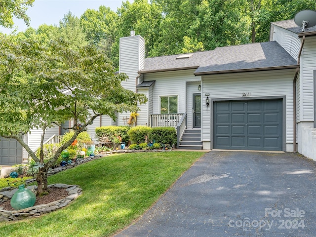 view of front of property with a garage and a front lawn