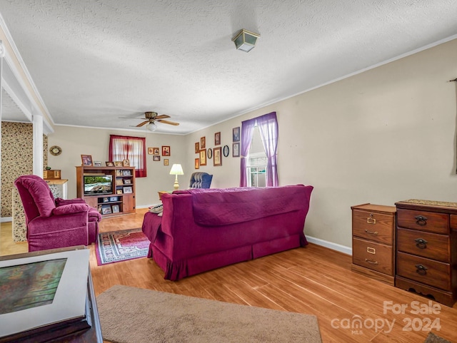 living room with a textured ceiling, light hardwood / wood-style floors, and ceiling fan