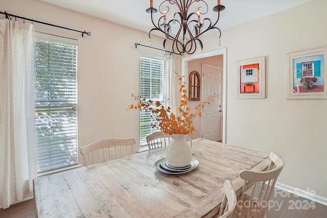 dining space featuring hardwood / wood-style floors and a chandelier