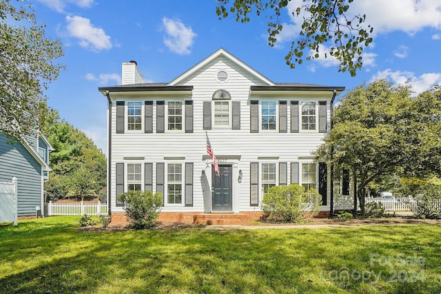 colonial home featuring a front lawn