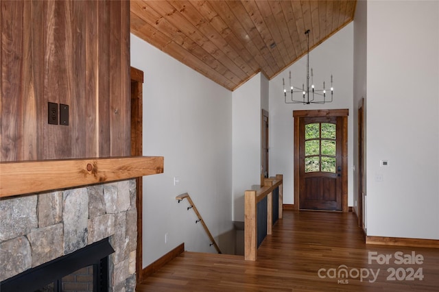 entrance foyer featuring an inviting chandelier, a stone fireplace, high vaulted ceiling, dark hardwood / wood-style flooring, and wooden ceiling