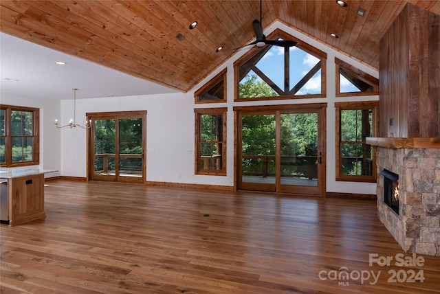 unfurnished living room with high vaulted ceiling, dark hardwood / wood-style floors, a stone fireplace, and wooden ceiling