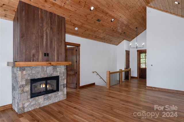 unfurnished living room with wood ceiling, hardwood / wood-style flooring, high vaulted ceiling, and a stone fireplace