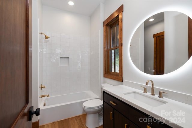 full bathroom featuring toilet, tiled shower / bath, vanity, and hardwood / wood-style flooring