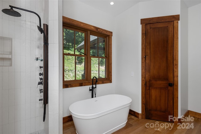 bathroom featuring hardwood / wood-style flooring and plus walk in shower