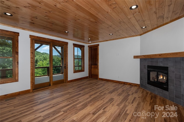 unfurnished living room featuring ornamental molding, wood ceiling, a fireplace, and hardwood / wood-style floors