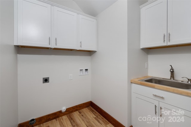 clothes washing area featuring cabinets, light hardwood / wood-style floors, washer hookup, sink, and hookup for an electric dryer