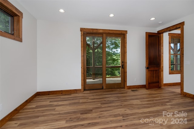 unfurnished room featuring a healthy amount of sunlight and hardwood / wood-style flooring