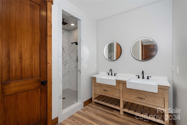 bathroom featuring vanity, hardwood / wood-style flooring, and tiled shower